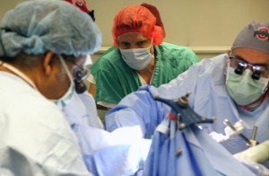 (Gracieuseté du Wexner Centre médical de l'Université Ohio State) - Les neurochirurgiens Milind Deogaonkar, à gauche, et Ali Rezai, à droite, de l'Ohio State University Wexner Centre Médical effectuer la chirurgie du cerveau pour implanter la technologie Neurobridge dans un 22-year-old man partiellement paralysé . 